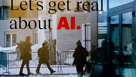 People reflected in a window of a hotel at the Davos Promenade with a slogan about AI alongside the World Economic Forum in Davos, Switzerland, Monday, January 15, 2024.