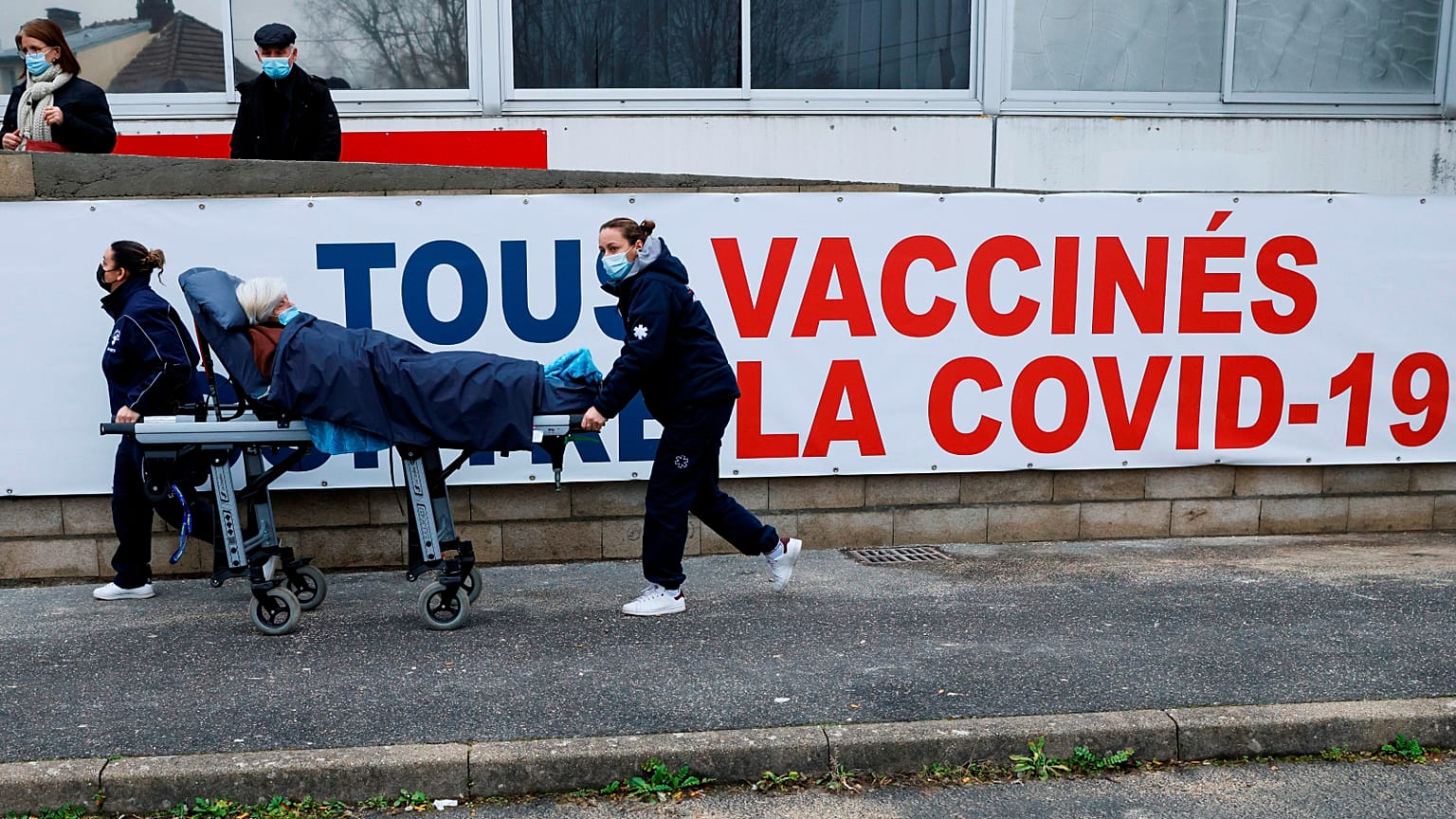 Una donna viene trasportata su una barella al centro di vaccinazione COVID-19 del Gruppo Ospedaliero Sud Ile-de-France a Melun, nella periferia di Parigi, febbraio 2021.