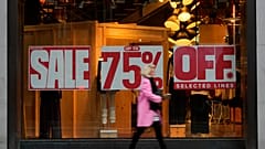 A shopper passes a window displaying a sale sign on Oxford Street in London, Wednesday, Dec. 20, 2023. 