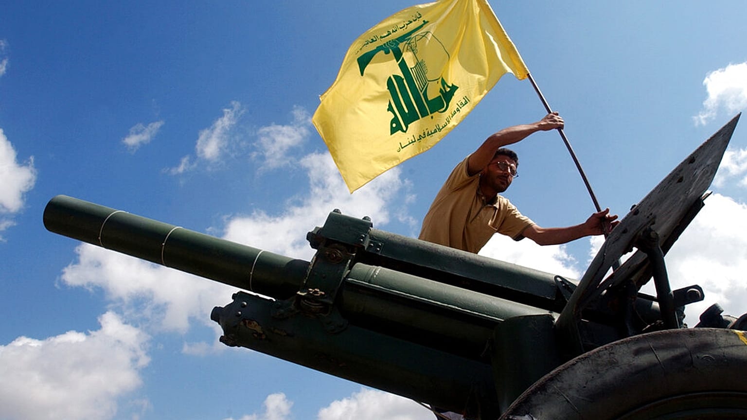 İsrail ile düşük yoğunluklu bir çatışma yürüten İran destekli Hizbullah örgütüne mensup bir savaşçı, örgütün bayrağını dikerken