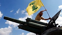 İsrail ile düşük yoğunluklu bir çatışma yürüten İran destekli Hizbullah örgütüne mensup bir savaşçı, örgütün bayrağını dikerken