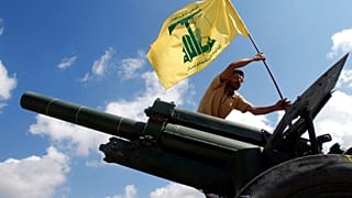 İsrail ile düşük yoğunluklu bir çatışma yürüten İran destekli Hizbullah örgütüne mensup bir savaşçı, örgütün bayrağını dikerken