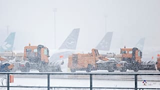 Snow clearing vehicles drive past parked airplanes at Frankfurt Airport during heavy snowfall in Frankfurt am Main, Germany, Thursday, Jan 18, 2024.