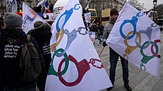 Police officers demonstrate with flags turning the olympic rings as handcuffs during a demonstration Wednesday, Jan. 10, 2024 in Paris.