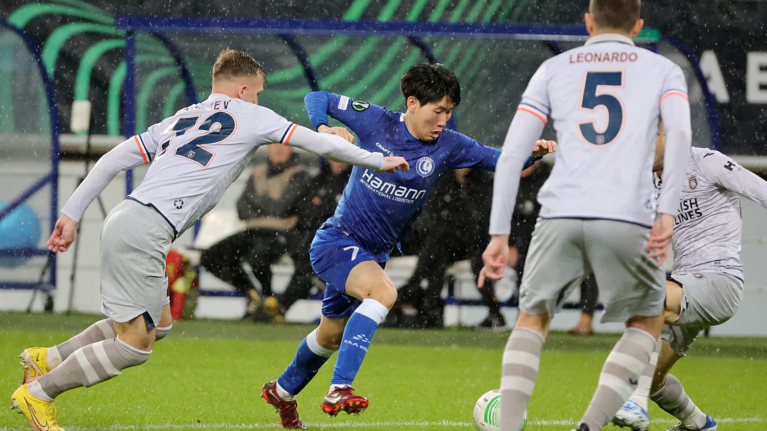 ARCHIVO - Eden Karzev, del Istanbul Basaksehir (izquierda), lucha por el balón con Hyunseok Hong, del Gent (centro), Bélgica, jueves 9 de marzo de 2023. 