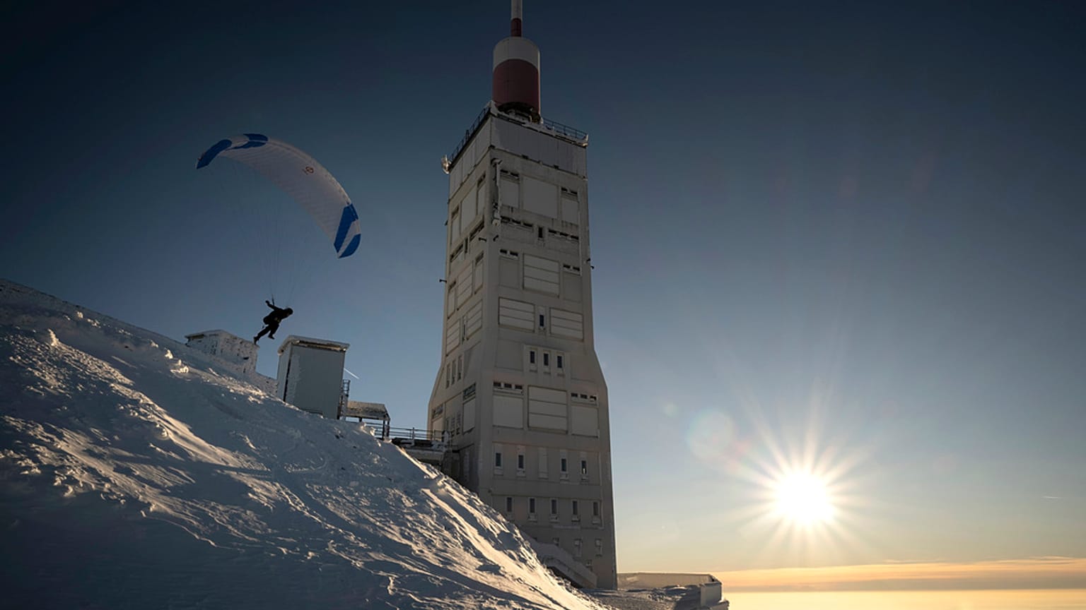 A paraglider takes off from the snow-covered Mont Ventoux, southeastern France, Saturday, Jan. 13, 2024