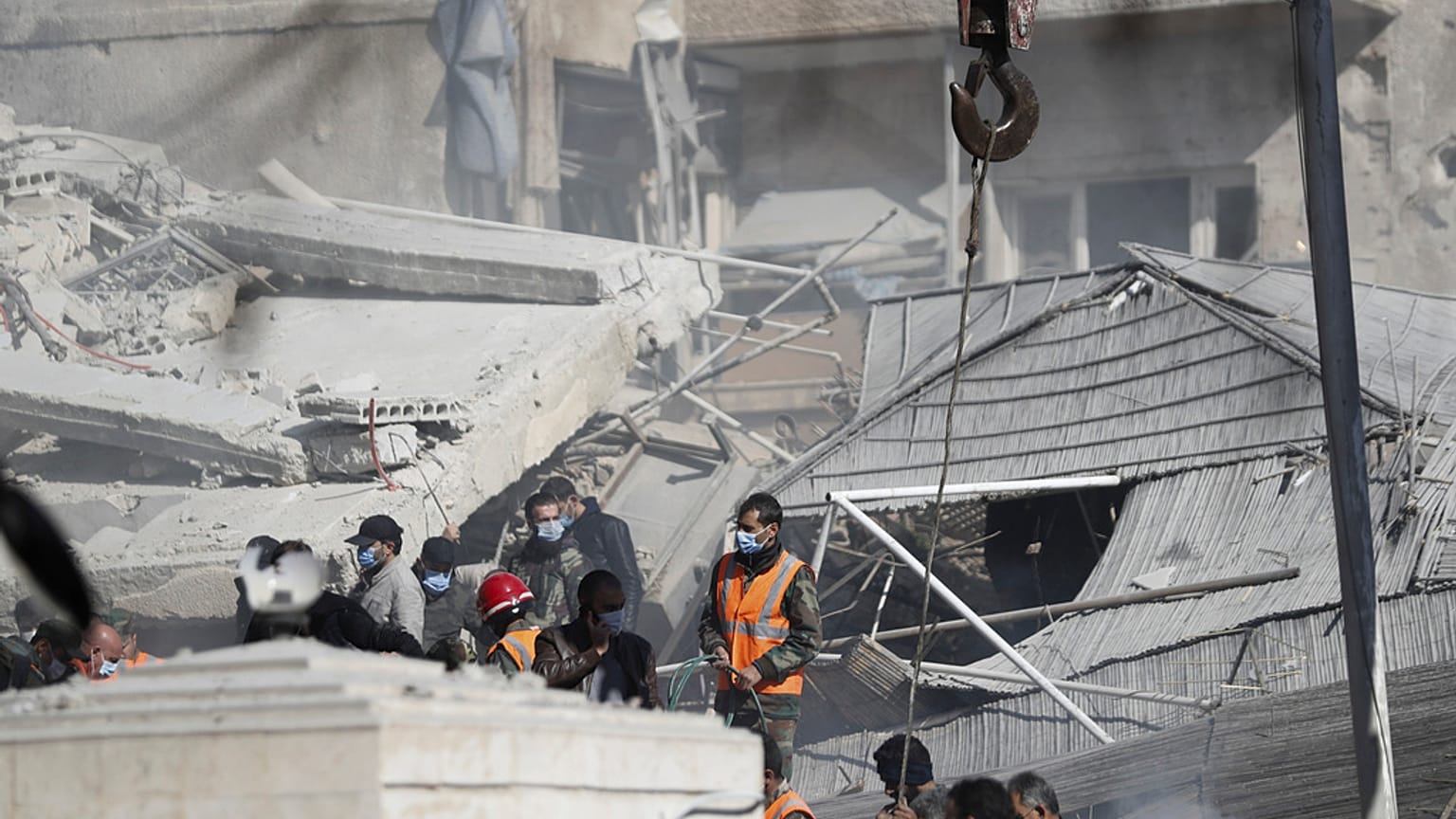 Emergency services work at a building hit by an air strike in Damascus, Syria on Saturday