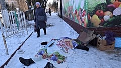 A woman walks past a body of a victim killed during the shelling that Russian officials in Donetsk 21/1/2024.