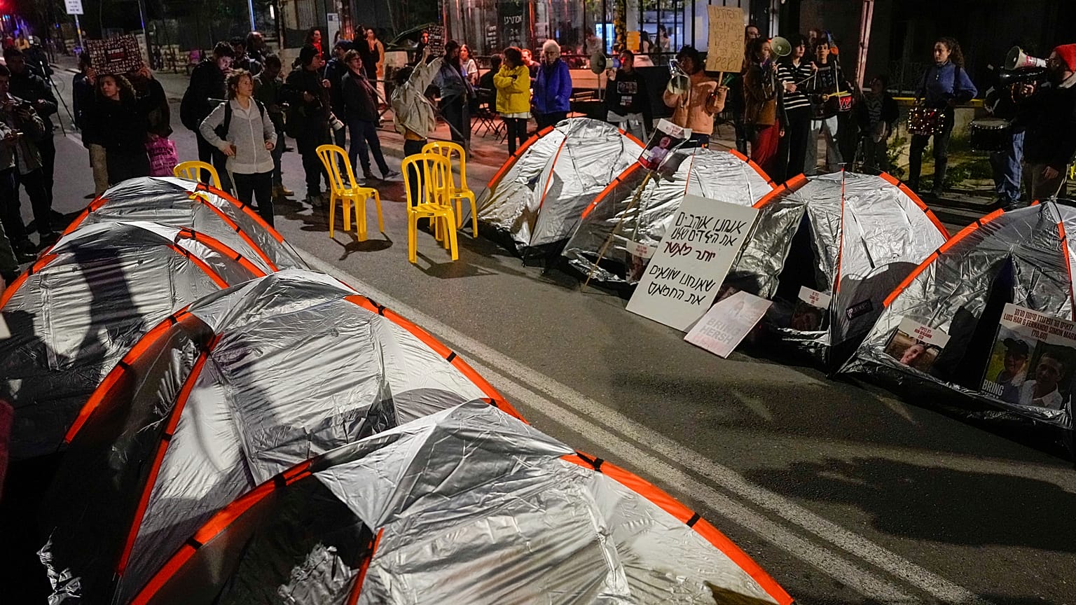 Familiares de rehenes israelíes y otros manifestantes bloquean una carretera con tiendas de campaña durante una protesta por fuera de la residencia de Netanyahu en Jerusalén