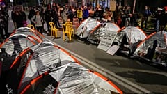 Familiares de rehenes israelíes y otros manifestantes bloquean una carretera con tiendas de campaña durante una protesta por fuera de la residencia de Netanyahu en Jerusalén