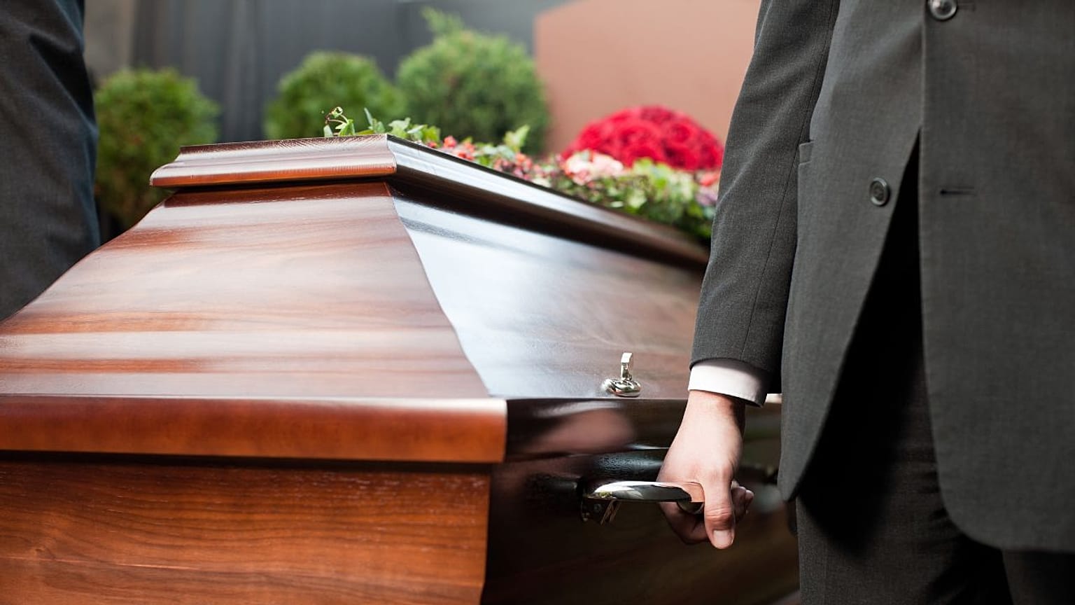 A man carries a coffin. 