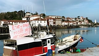 Una pancarta dice "Estado + ONG equivale a la muerte de la pesca artesanal" en el puerto de San Juan de Luz, en el suroeste de Francia, el jueves 30 de marzo de 2023.