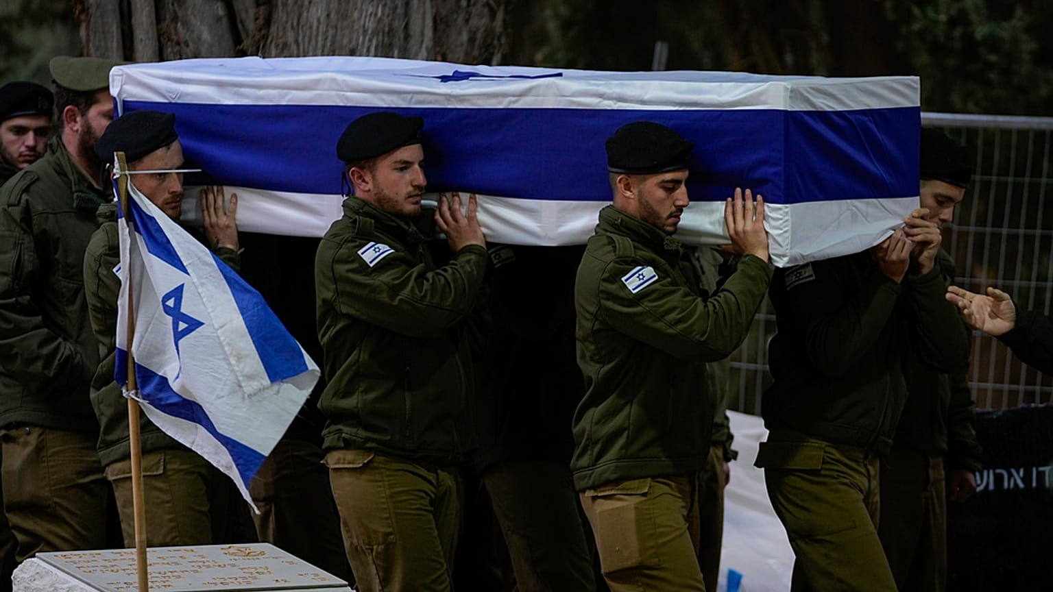 Soldados israelíes portan el féretro envuelto en una bandera del reservista Hadar Kapeluk durante su funeral en el cementerio militar de Monte Herzl en Jerusalén.