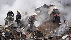 Des secouristes travaillent sur les lieux d'un bâtiment endommagé par une attaque à la roquette russe à Kharkiv, en Ukraine, le mardi 23 janvier 2024.