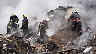 Des secouristes travaillent sur les lieux d'un bâtiment endommagé par une attaque à la roquette russe à Kharkiv, en Ukraine, le mardi 23 janvier 2024.