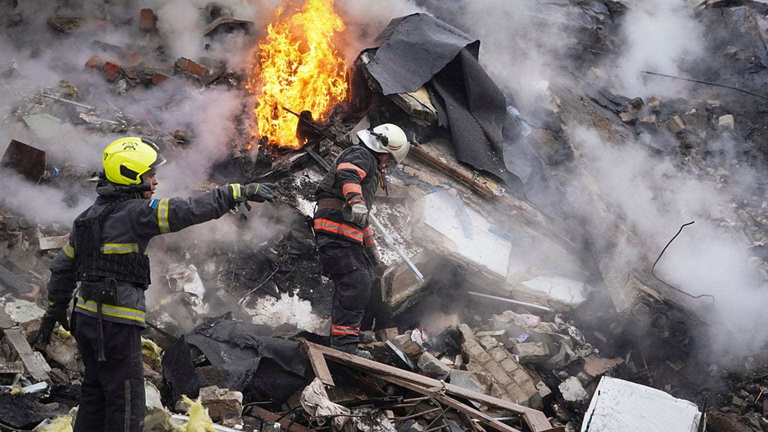Des sauveteurs interviennent sur les lieux d'un bâtiment endommagé par une attaque à la roquette russe à Kharkiv, en Ukraine, le mardi 23 janvier 2024.
