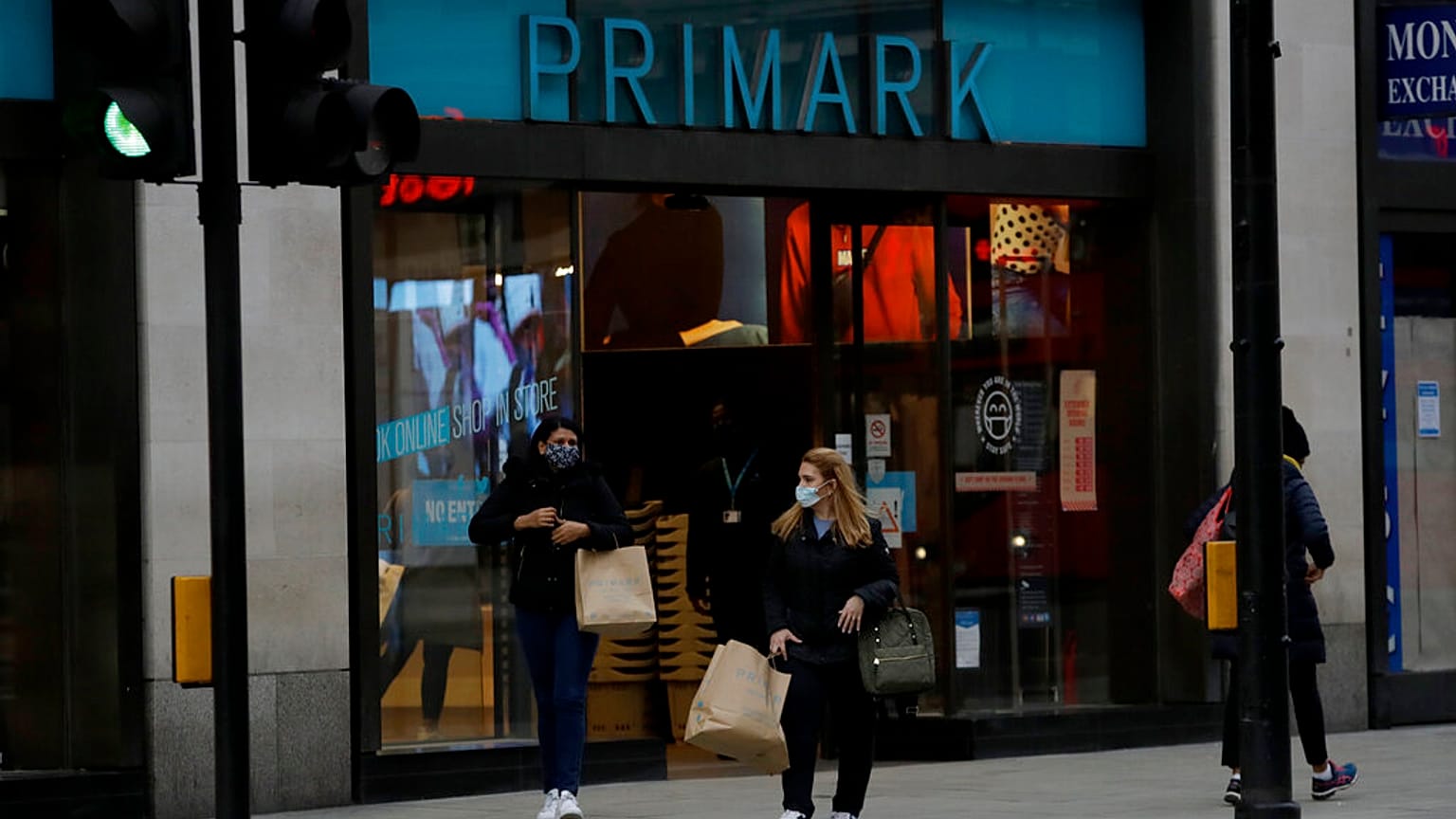 Women carry shopping bags as they leave a Primark clothes store on Oxford Street. 