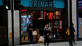 Women carry shopping bags as they leave a Primark clothes store on Oxford Street. 