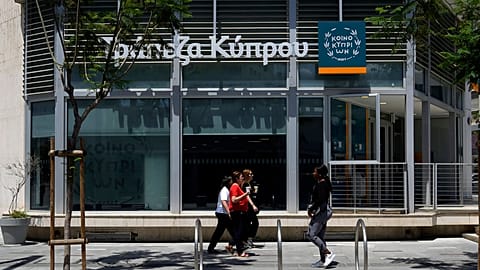 Women walk outside of a branch of Bank of Cyprus at a main shopping street in capital Nicosia, Cyprus in 2023