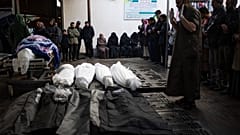Ciudadanos palestinos rezan junto a los cuerpos de los fallecidos en la ofensiva terrestre israelí y el bombardeo de Jan Yunis, frente a un depósito de cadáveres en Rafah.