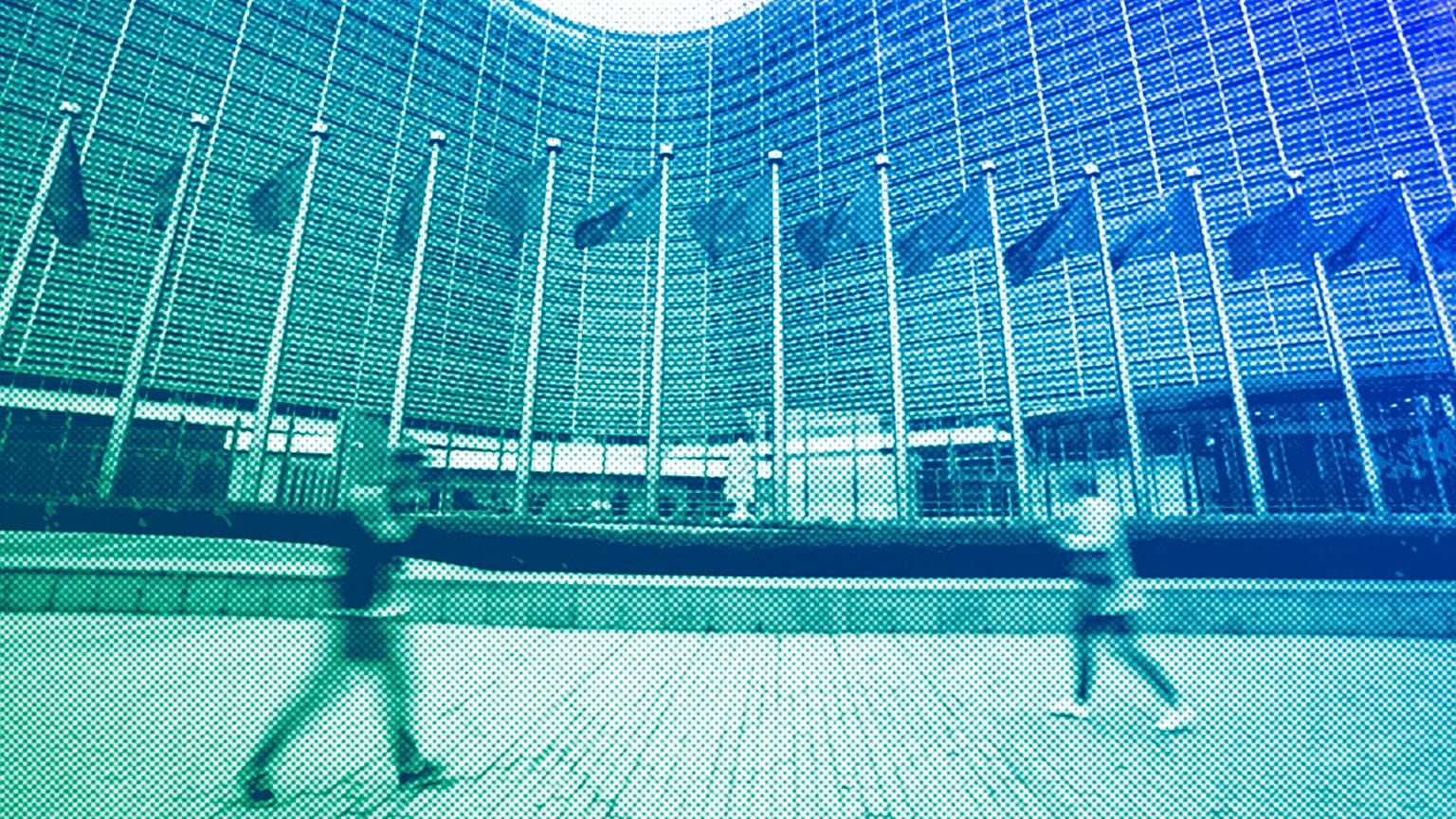 European Union flags wave in the wind as pedestrians walk by EU headquarters in Brussels, November 2023