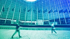 European Union flags wave in the wind as pedestrians walk by EU headquarters in Brussels, November 2023
