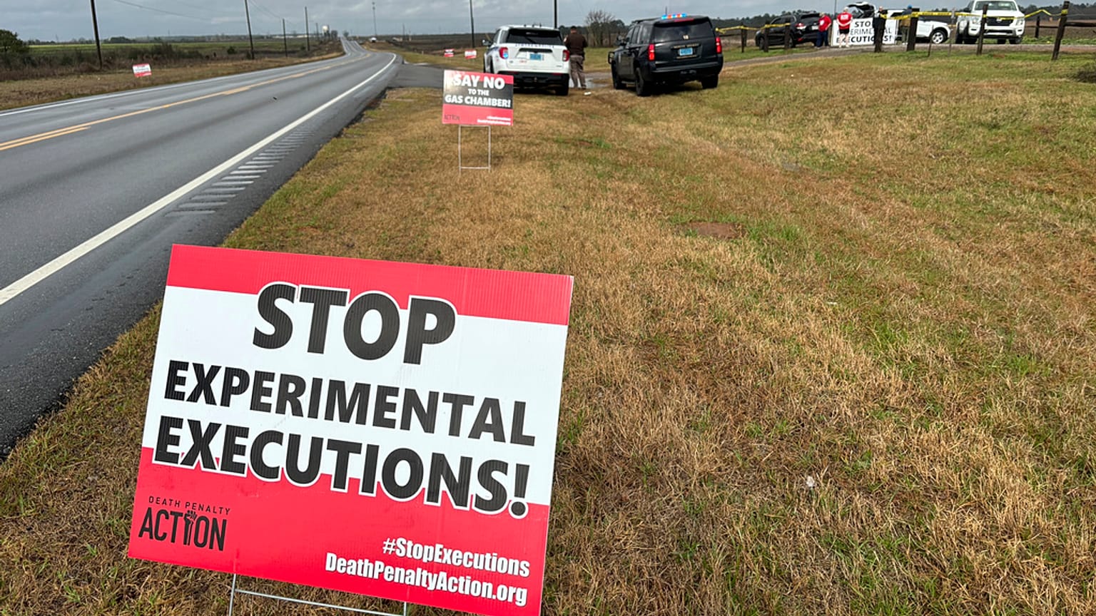 Anti-death penalty activists place signs along the road heading to Holman Correctional Facility in Atmore, Ala., ahead of the execution of Smith on Thursday.