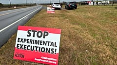 Anti-death penalty activists place signs along the road heading to Holman Correctional Facility in Atmore, Ala., ahead of the execution of Smith on Thursday.