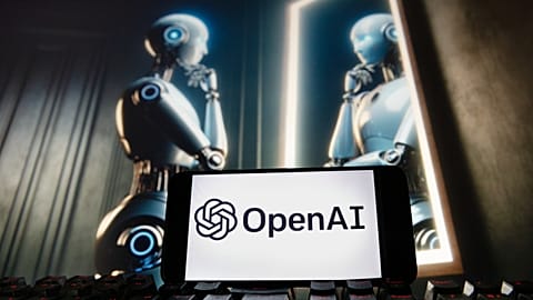 The OpenAI logo is seen displayed on a cell phone with an image on a computer monitor generated by ChatGPT's Dall-E text-to-image model, Friday, Dec. 8, 2023, in Boston. 