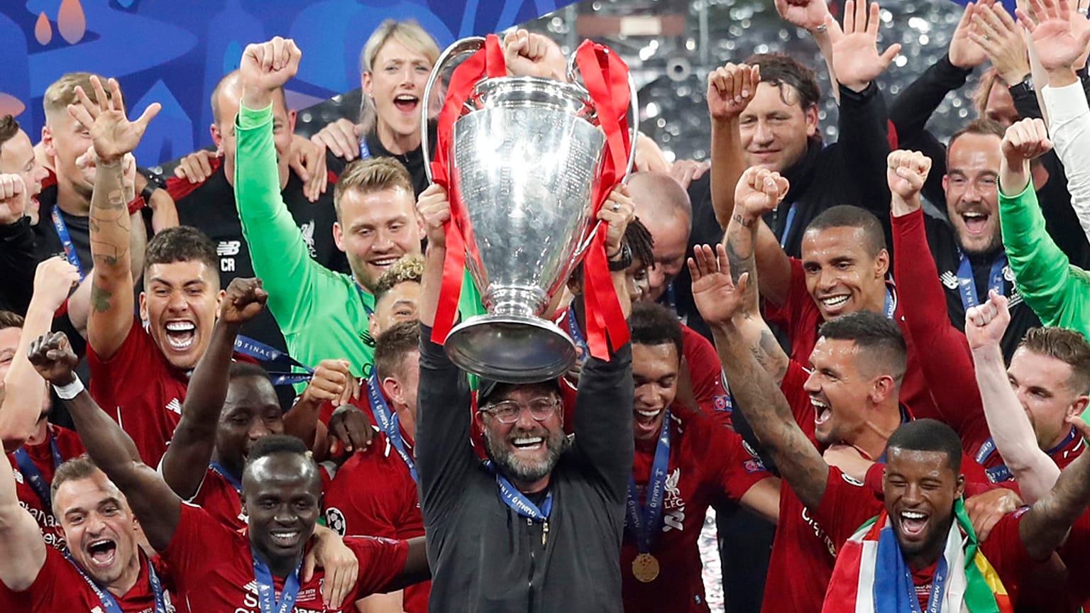 Liverpool coach Juergen Klopp lifts up the trophy as he celebrates with players after winning the Champions League final soccer match between Tottenham Hotspur and Liverpool 