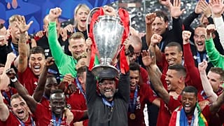 Liverpool coach Juergen Klopp lifts up the trophy as he celebrates with players after winning the Champions League final soccer match between Tottenham Hotspur and Liverpool