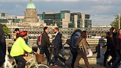 In this picture taken on Monday, Oct. 6, 2014, pedestrians and cyclists pass each other at evening rush hour on O'Connell Bridge in central Dublin.