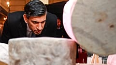 Britain's Prime Minister Rishi Sunak looks at cheeses as he visits a food and drinks market promoting British small businesses at Downing Street in London in 2022