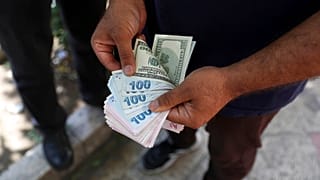 A street money exchanger poses for a photo without showing his face as he counts foreign banknotes in Ferdowsi street, Tehran's go-to venue for foreign currency exchange, Iran