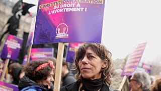 A woman demonstrates with a poster reading "Abortion in the Constitution" as part of the International Women's Day, Wednesday, March 8, 2023 in Paris.