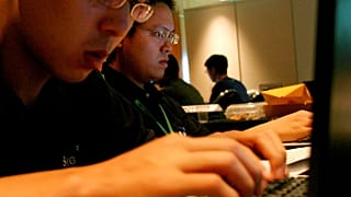 Singapur'da düzenlenen bir bilgisayar korsanlığı yarışmasına katılan yarışmacılar dizüstü bilgisayarlarında çalışırken (2005)