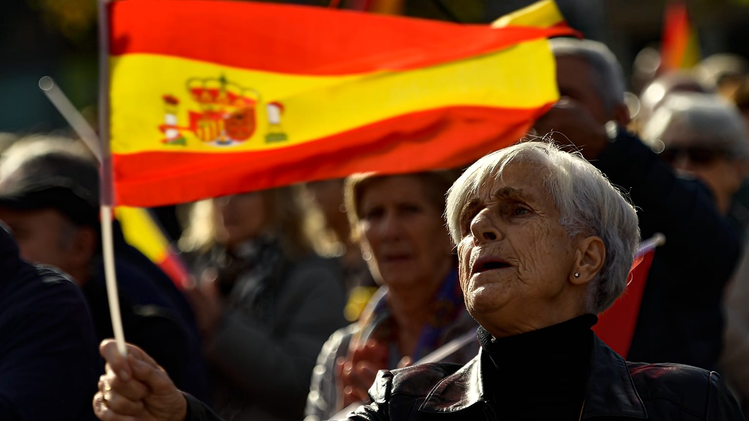 Una mujer con la bandera española mientras protesta contra la amnistía en la Plaza del Castillo, en Pamplona, norte de España, el sábado 18 de noviembre de 2023.