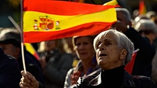 Una mujer con la bandera española mientras protesta contra la amnistía en la Plaza del Castillo, en Pamplona, norte de España, el sábado 18 de noviembre de 2023.