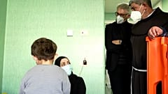 Franziskanerpater Ibrahim Faltas bescht vor laufender Kamera eine palästinensische Familie in einem Krankenhaus in Rom.
