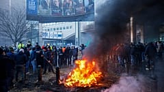 Farmers burn straw and tyres during a protest outside the European Parliament as European leaders meet for an EU summit in Brussels, Thursday, Feb. 1,