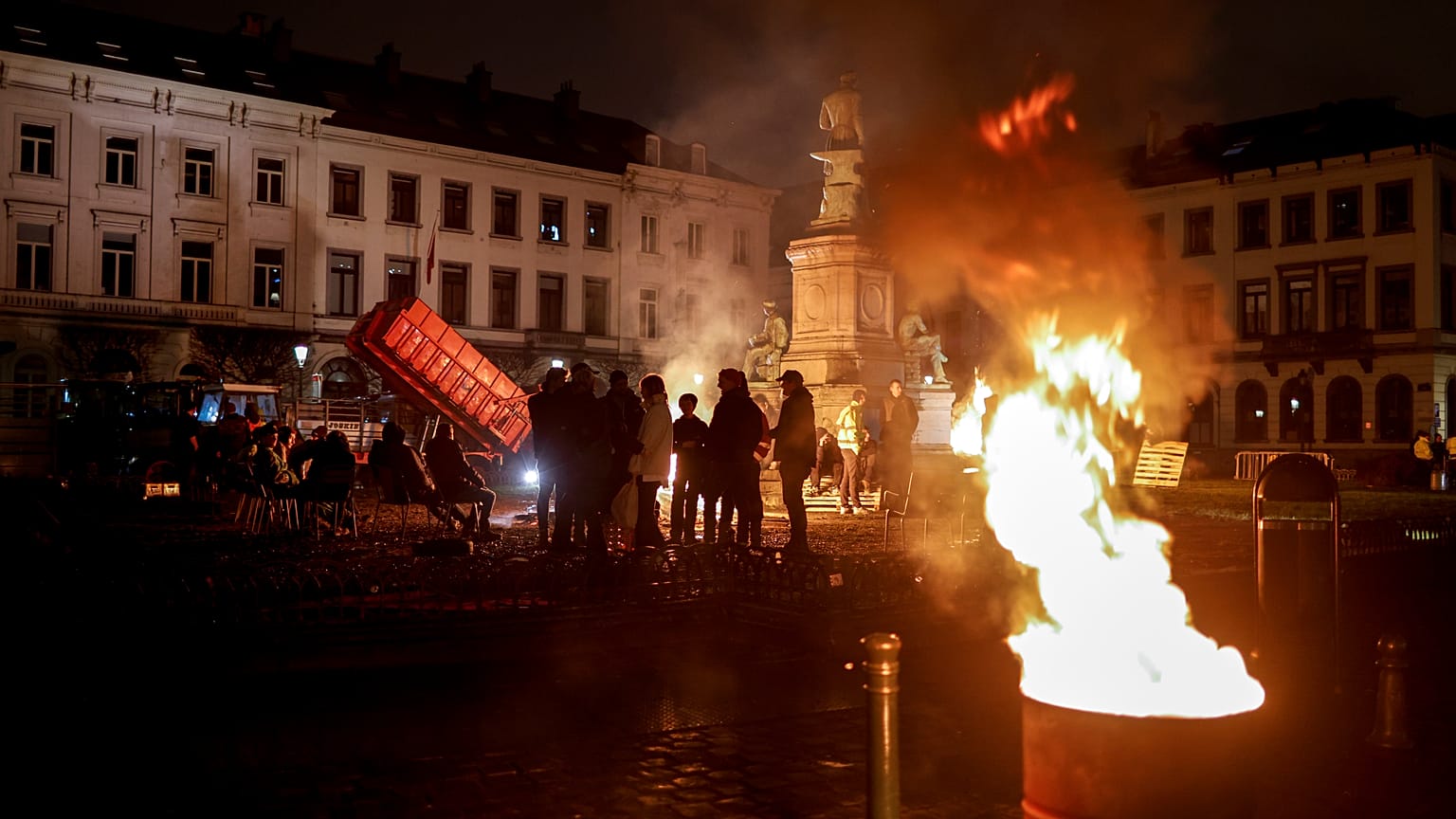 Los agricultores entran en calor con fogatas durante la madrugada mientras se reúnen para protestar en Bruselas antes de la cumbre de la UE este jueves