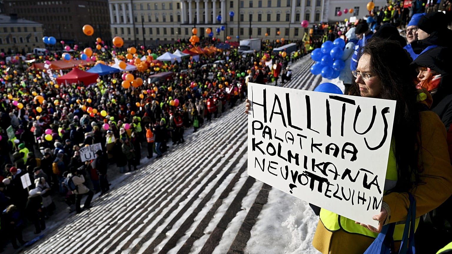 Kirsi Harju sostiene una pancarta en Stop Now! Manifestación contra las reformas laborales del Gobierno de Finlandia en Helsinki, Finlandia, el 1 de febrero de 2024.