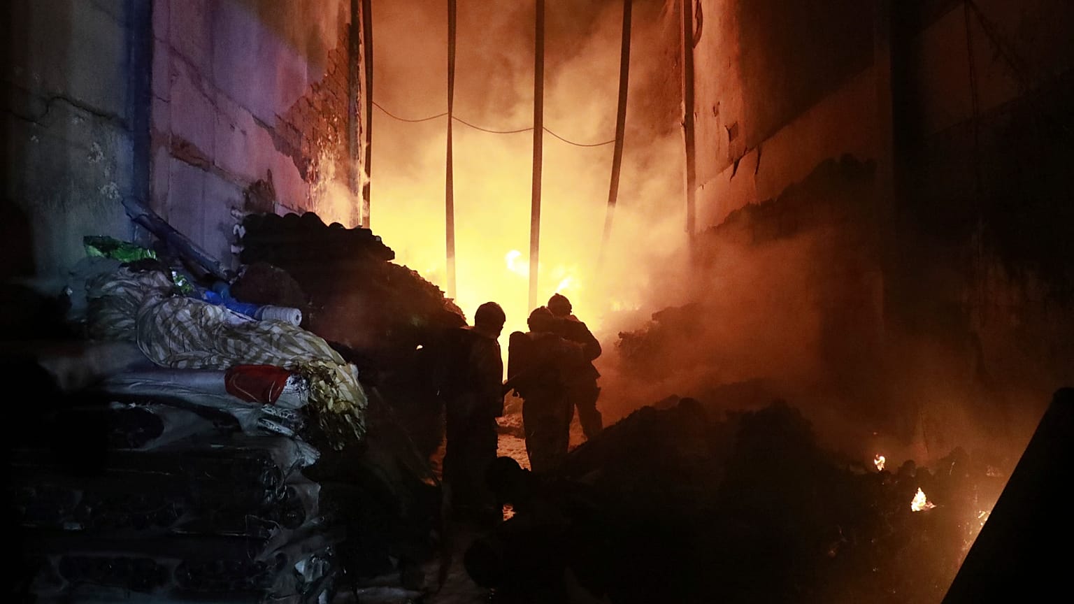 Кенийские пожарные работают на заправке, где взорвался грузовик с газом. 