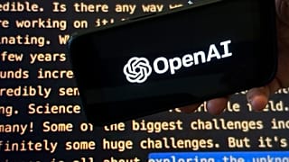Il logo OpenAI appare su un telefono cellulare davanti a una schermata che mostra parte del sito web dell'azienda.