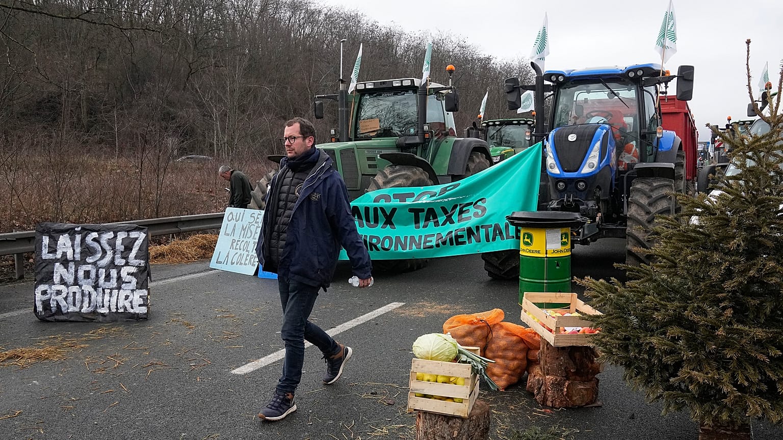 Un agricoltore passa davanti alle scorte su un'autostrada bloccata ad Argenteuil, a nord di Parigi (1 febbraio 2024)