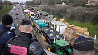 پلیس فرانسه در حال نظاره کردن مسدود شدن یک بزرگراه منتهی به شهر پاریس توسط کشاورزان معترض در روز ۳۱ ژانویه ۲۰۲۴