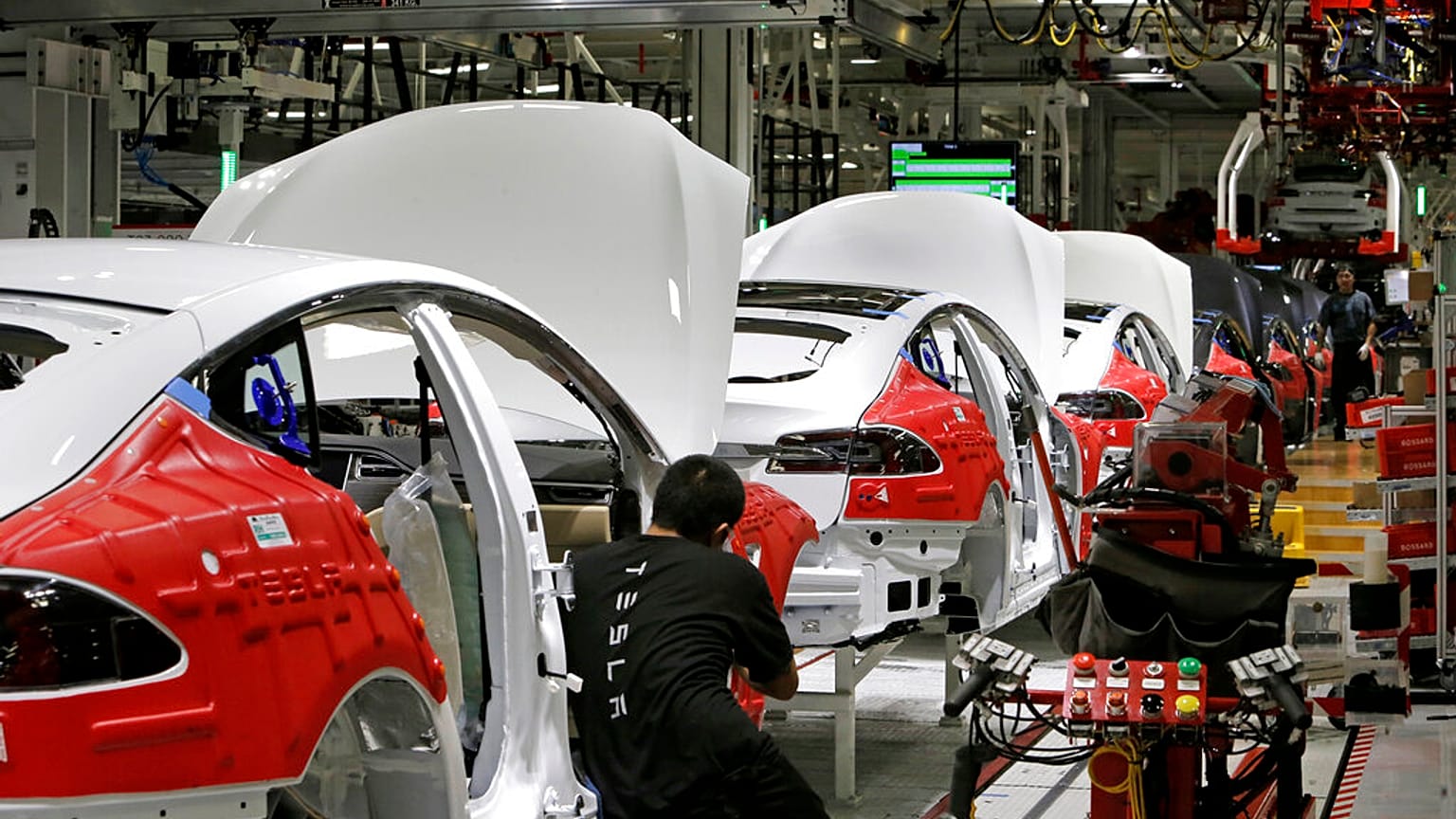 Cars move through the assembly line at Tesla Motors, California's only full-scale auto manufacturing plant
