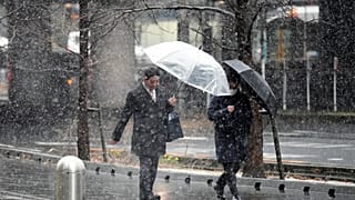 Varios ciudadanos japoneses caminan por una calle de Tokio cubierta por un manto de nieve, el lunes 5 de febrero 2024. 
