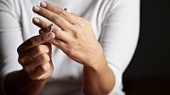 A woman removes a wedding ring