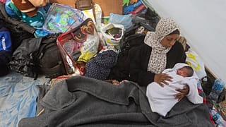 نازحة فلسطينية في رفح تحمل مولودها الجديد